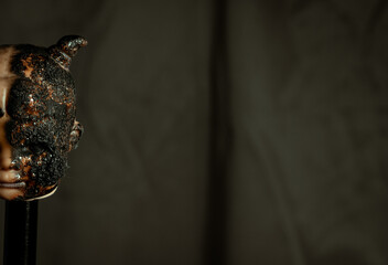 Damaged Dirty burnt Doll head on grey background