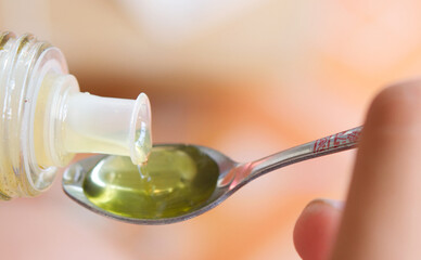 olive oil pouring into spoon