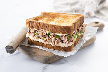 Tuna sandwich with mayo and vegetables on marble background