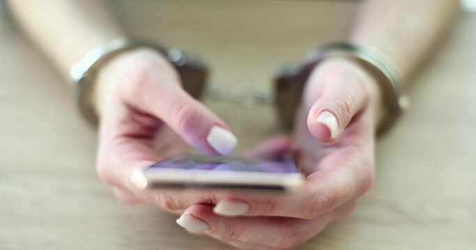Handcuffed hands holding smartphone and phone scam
