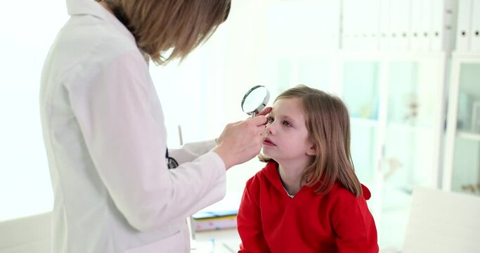 Ophthalmologist checks eye of small child or performs postoperative examination using special equipment
