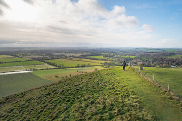 Fototapeta na wymiar backpacker walking on footpath, beautiful hill and landscape near Pewsey, South of England, United Kingdom