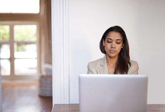 Never far from her laptop. a young woman working on a laptop.