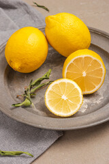 Lemon and sliced lemon in a dish and a grey napkin green leaf , blank space for advertising