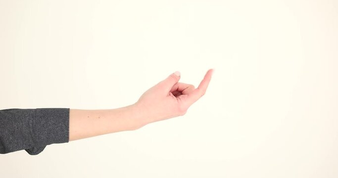 Woman hand beckons with index finger on white background