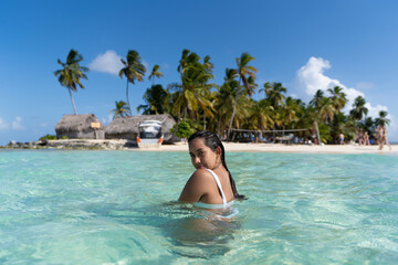 Beautiful tan Colombian women in crystal Caribbean sea water in San Blas Palm tree Islands, Panama