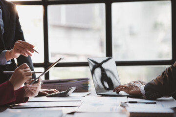 Group business people are reviewing monthly sales documents analysis and marketing plans for more sales growth, they are the founders of young companies co-founding startups. Sales management concept.