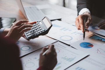 Group business people are brainstorming together and reviewing the company financial documents that the finance department has summarized, they are business partners. Business administration concept.