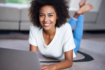 You should read my blog sometime. Portrait of a young woman lying on the floor with her laptop.