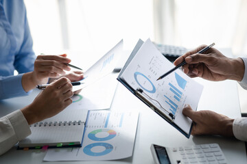 Company meeting room has businessmen and finance managers meeting together on finance topics, they are looking at information on documents and discussing together. Concept company financial management