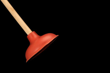 Isolate of toilet plunger on black background. . Plumbers drain cleaner tool. Red rubber cup plunger. Equipment for clearing blockages.