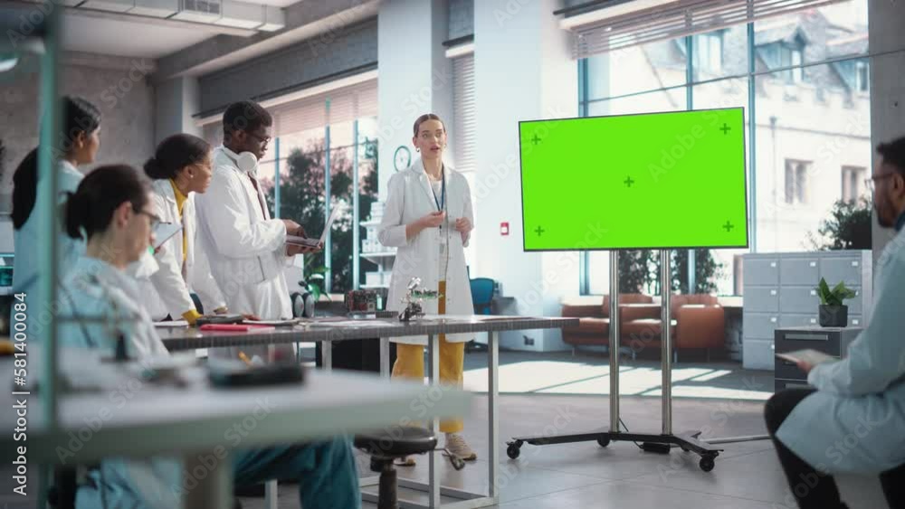 Leinwandbilder group of students listening to their robotics female professor who uses green screen monitor in a la