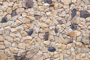 Abstract background texture of the stone wall. Coarse beige and gray stone. Stonework.