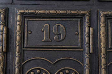 Number 19 on metal door. Old vintage retro copper plate with the number nineteen. Antique mailboxes.