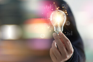 New ideas with innovative technology and creativity, Idea, innovation and inspiration concept, creativity with hand draw light bulbs that shine glitter, Hand of man holding illuminated light bulb..