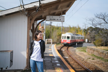 ローカル線の無人駅にいる女性