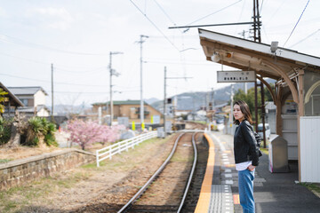 Naklejka premium ローカル線の無人駅にいる女性