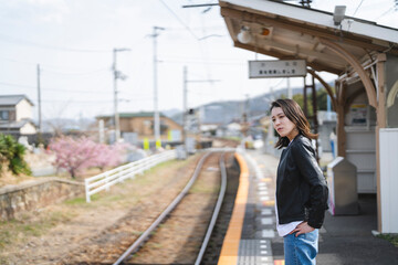 ローカル線の無人駅にいる女性