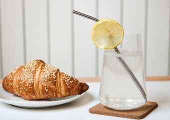 Croissant and lemonade. Tasty and crunchy breakfast in the restaurant