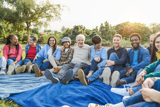 Group of multigenerational people smiling in front of camera - Multiracial friends with different ages having fun together - Main focus on caucasian senior face