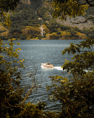 Motorboat in a lake with waterfall view