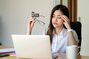 Fatigued businesswoman taking off glasses tired of computer work