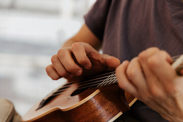 man playing ukulele, close up