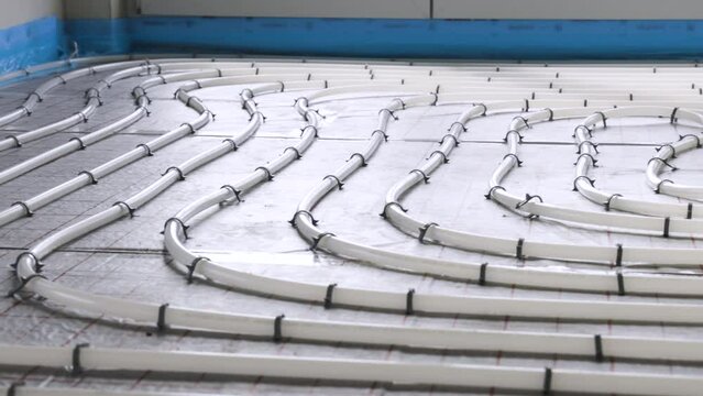 Panning shot of hydronic underfloor heating pipes inside a building

