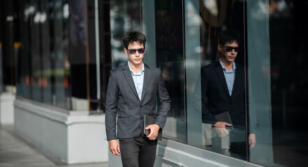 Confident male entrepreneur looking at the camera while standing. Young businessman standing in the out side of business center.