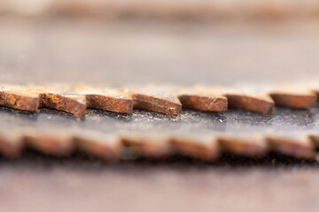 Worn out rusty circular saw blades, macro abstract defocused background, copy space, teeth detail