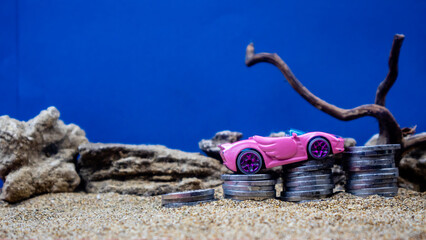 minahasa, Indonesia : January 2023, toy car on a pile of coins, saving for the future, managing...