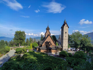 Old wooden Vang stave church with stone tower in summer. Karkonosze mountains, Karpacz, Poland