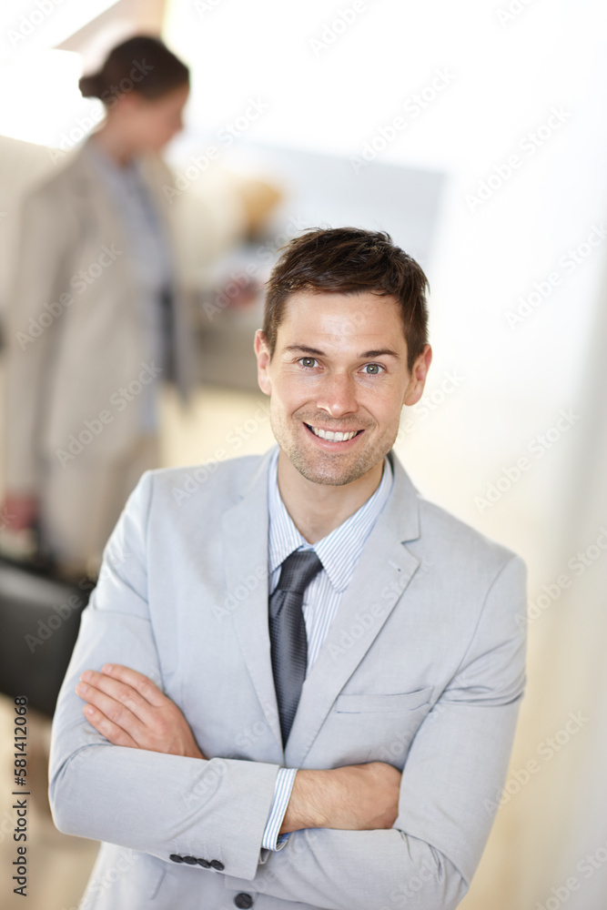 Canvas Prints Dressed for success. a handsome businessman standing at work with a colleague in the background.