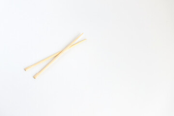 Pair of bamboo chopsticks for one person isolated over white background. Widely used in eastern, Asian culture.