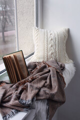 Soft comfortable beautiful knitted pillow on the window