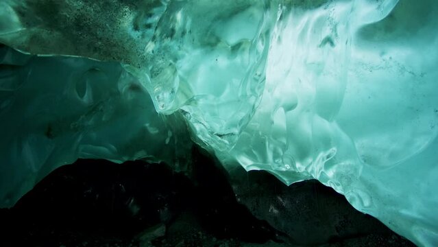 The ice under the rocks gradually melts and forms rivers. Turquoise ice. Exploring the Hidden Wonders of Alaska's Rock Ice Formation. USA., 2017