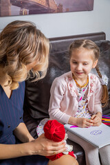 Naklejka premium The girl psychologist plays a puppet character game with the child
