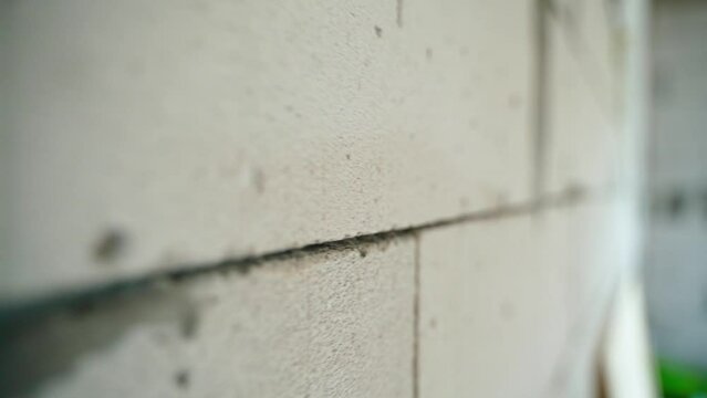 Seam of aerated concrete brick wall close-up. Smooth camera movement along the gas block masonry