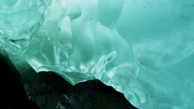 The ice under the rocks gradually melts and forms rivers. Turquoise ice. Exploring the Hidden Wonders of Alaska's Rock Ice Formation. USA., 2017