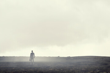Back view of young businessman while standing with mist background