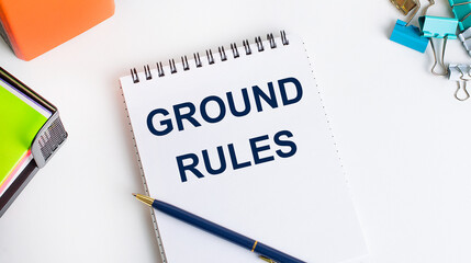 Office worker's desk, notepad with GROUND RULES text, pen, stationery