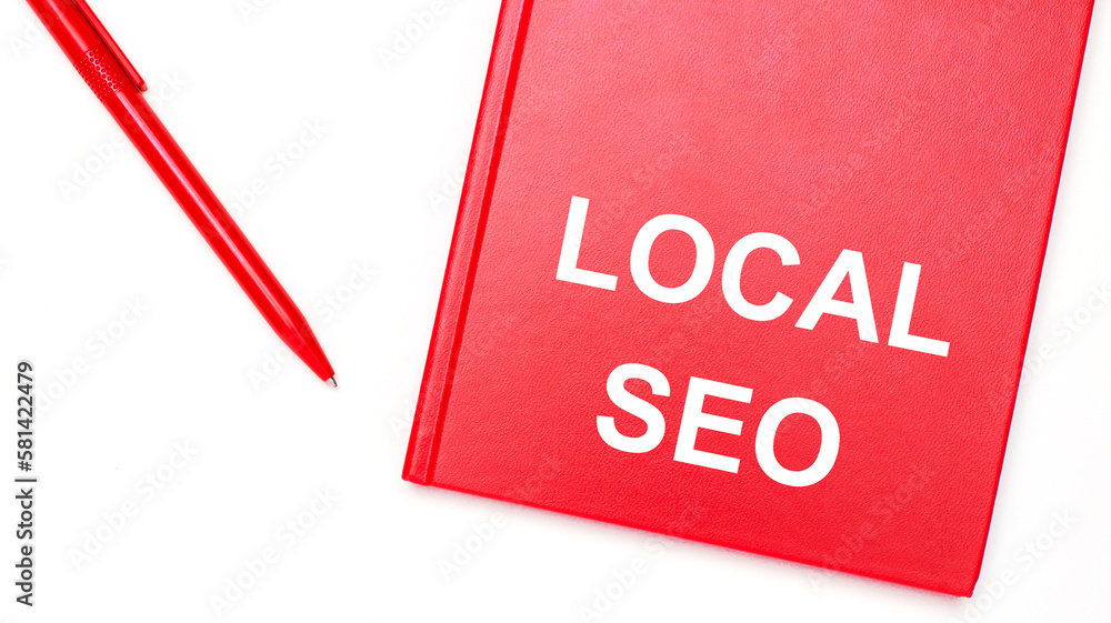 Poster the text local seo is written on a red notepad near a red pen on a white table in the office. busine