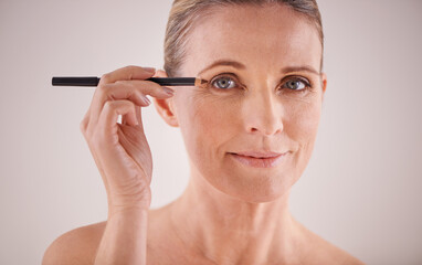 Fototapeta premium Highlighting her natural beauty. Cropped portrait of a beautiful mature woman applying eyeliner.