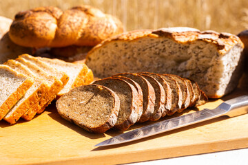 lot of different flavored bread, wheat, rye, on the table in the field outside