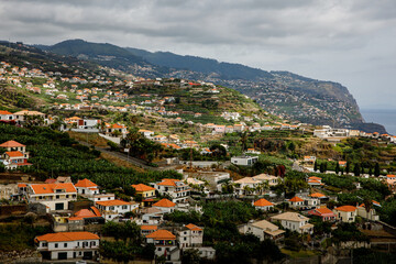 Fototapeta na wymiar Houses with red roofs on the slopes of the mountains of Madeira island in the Atlantic ocean.