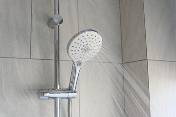 Close up shower head in modern bathroom with water drops flowing.Sanitary ware for bathroom...
