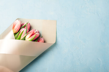 Bouquet of pink tulips on a blue background.Greeting card.