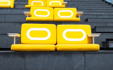 Yellow sit cushions on stairs, black outdoors in bright sunlight on rooftop of tall building....