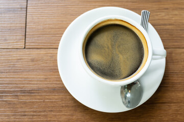 Top view Hot coffee in the white cup  on wooden table background..Cafe drinking menu black coffee at the restaurant with copy space.