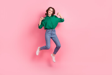 Full length photo of cute excited lady dressed green blouse pointing thumbs herself jumping emtpy space isolated pink color background